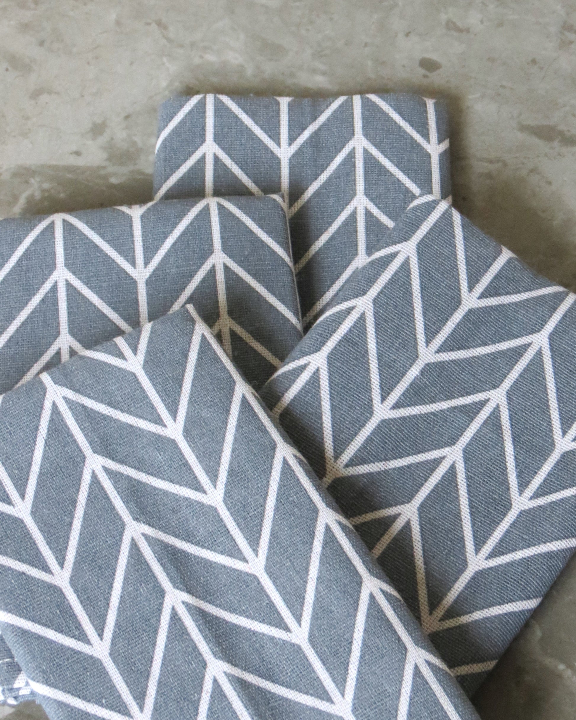 Grey fabric with white geometric pattern on a concrete surface