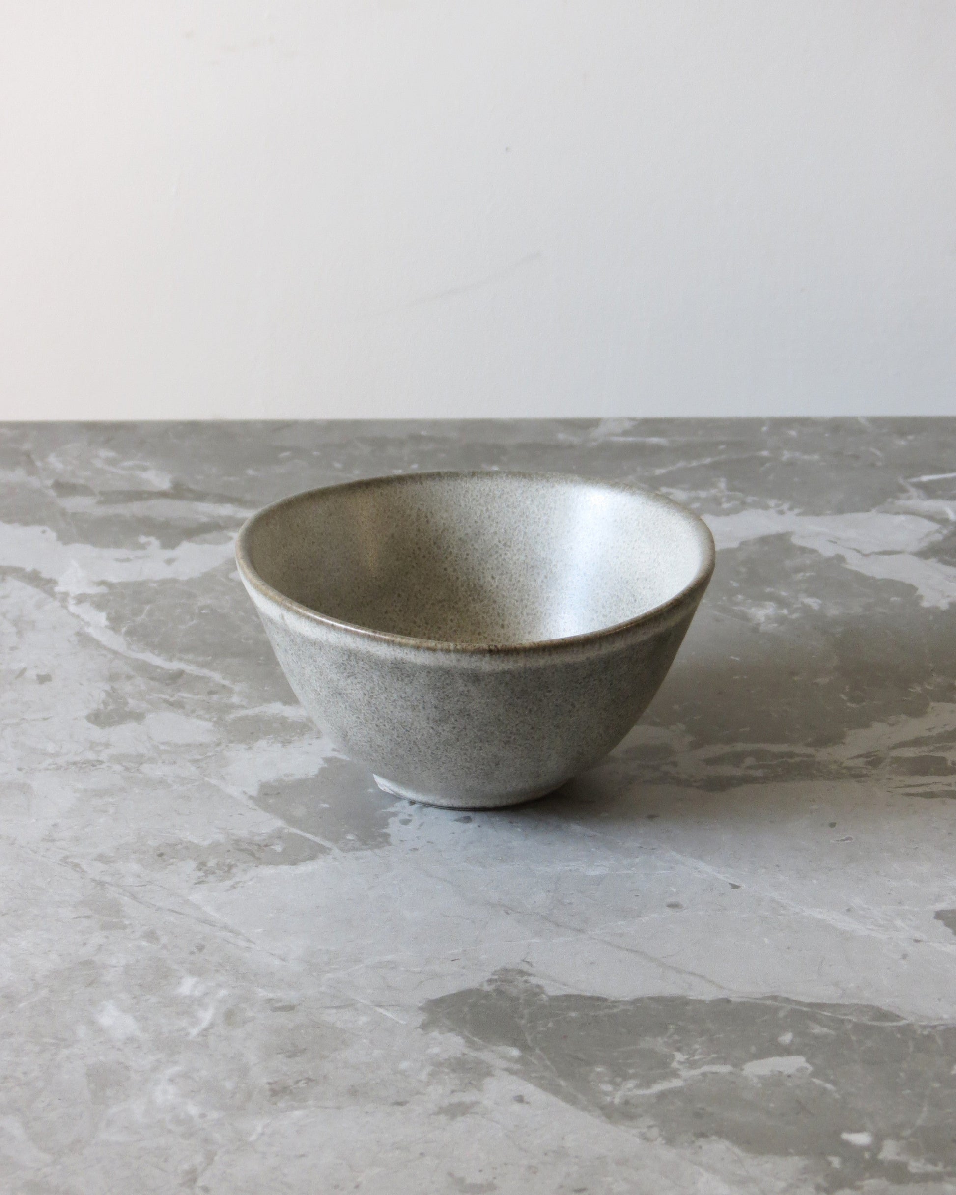 Gray ceramic bowl on a textured grey surface