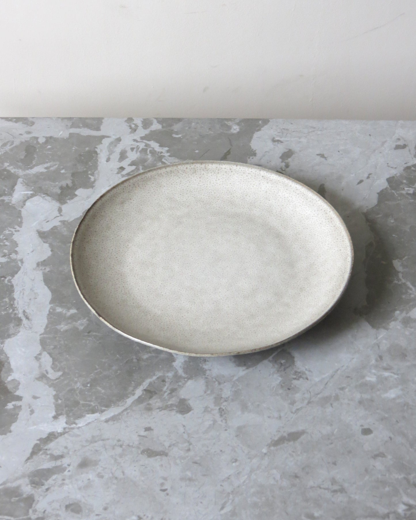 Round ceramic plate on a textured grey surface