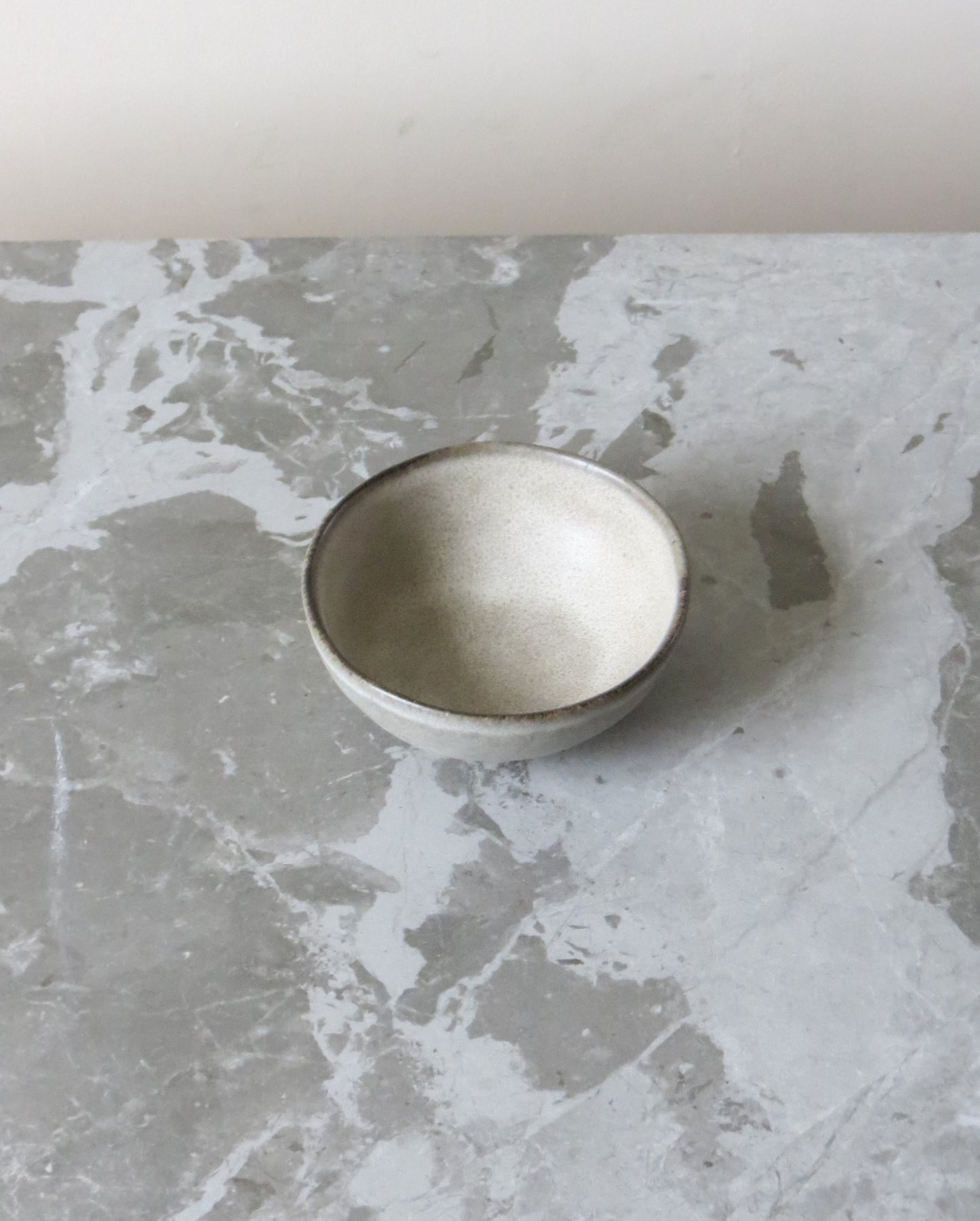 Small ceramic bowl on a textured grey surface