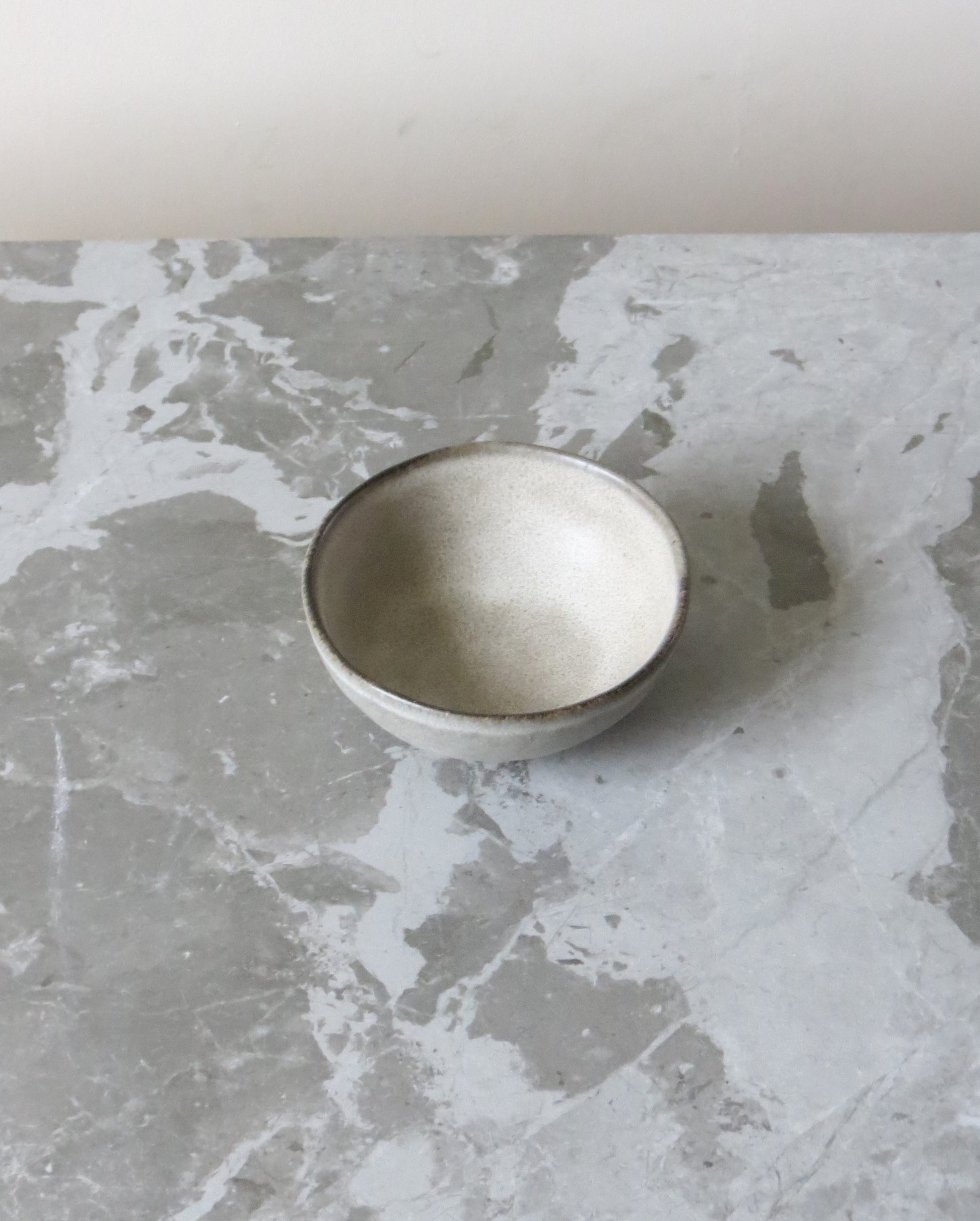 Small ceramic bowl on a textured grey surface
