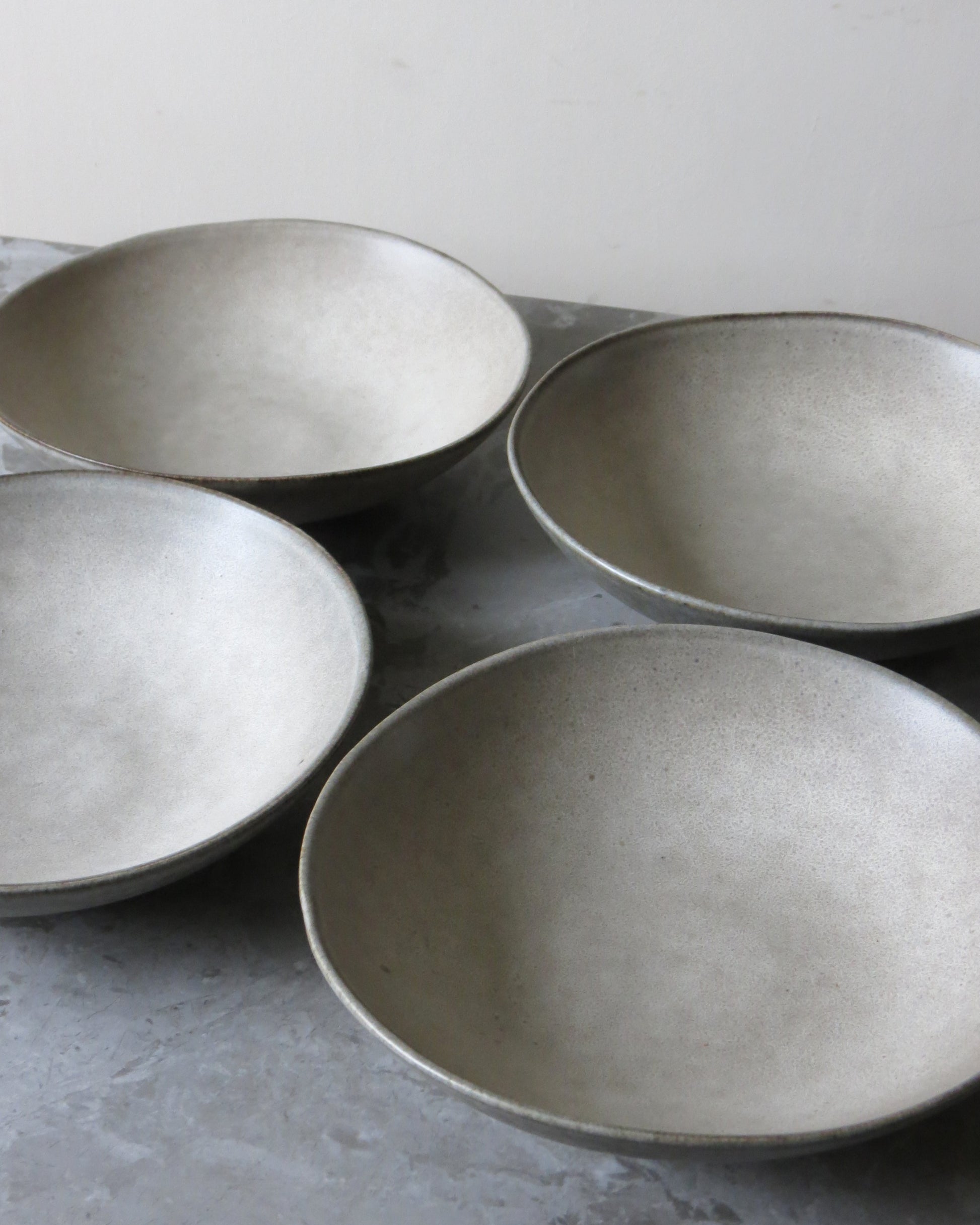 Four ceramic bowls on a grey background