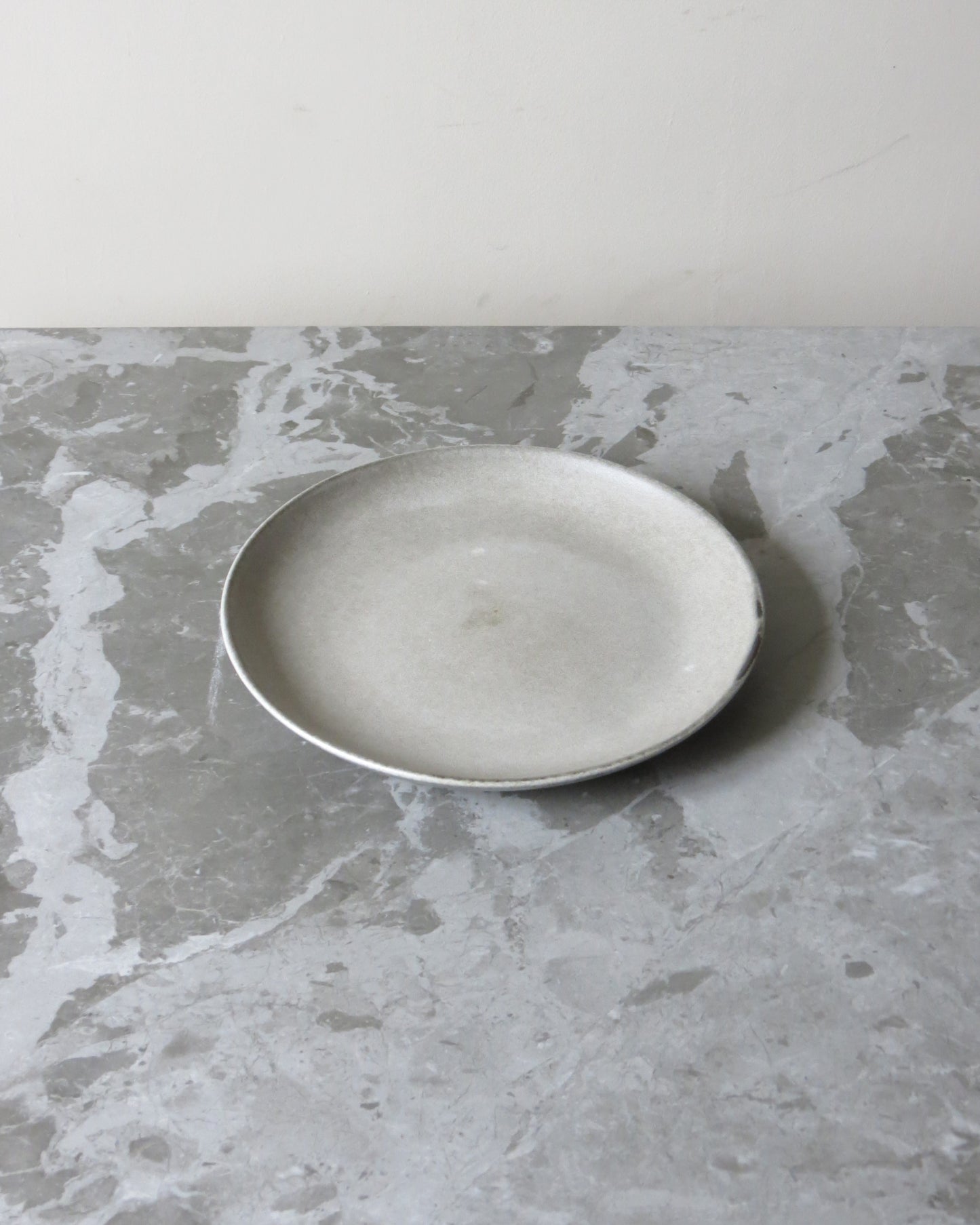 White ceramic plate on a grey marble surface
