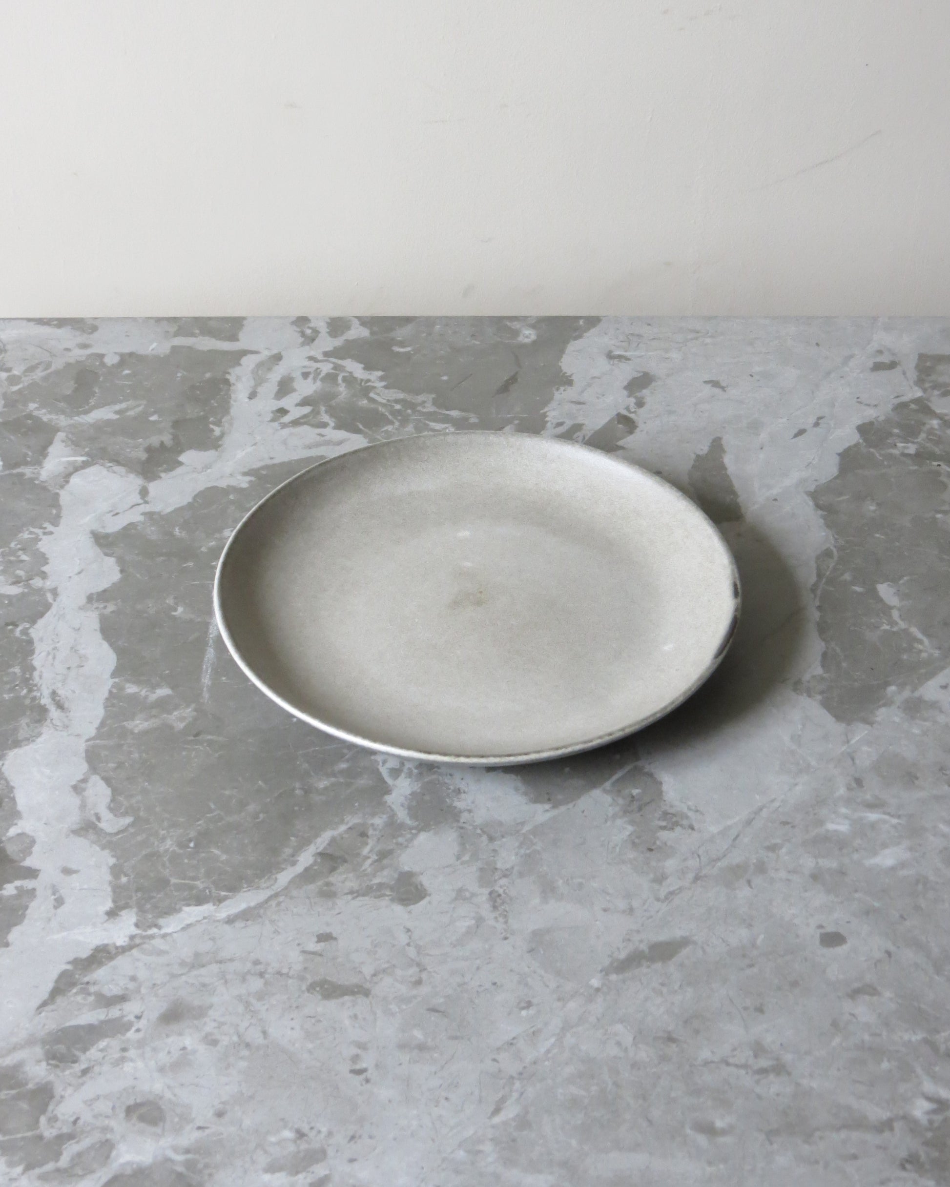 White ceramic plate on a grey marble surface
