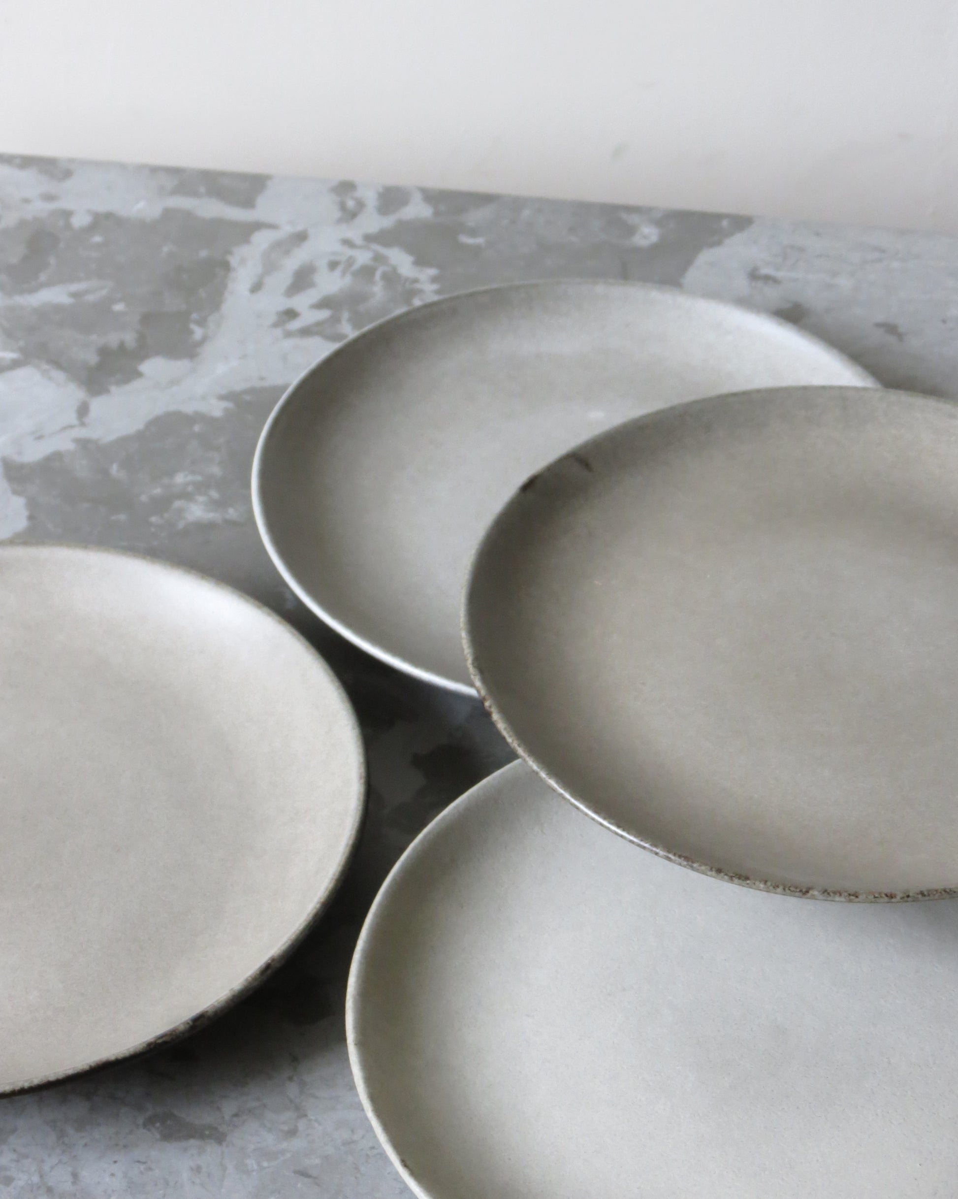 Set of ceramic plates on a textured grey surface