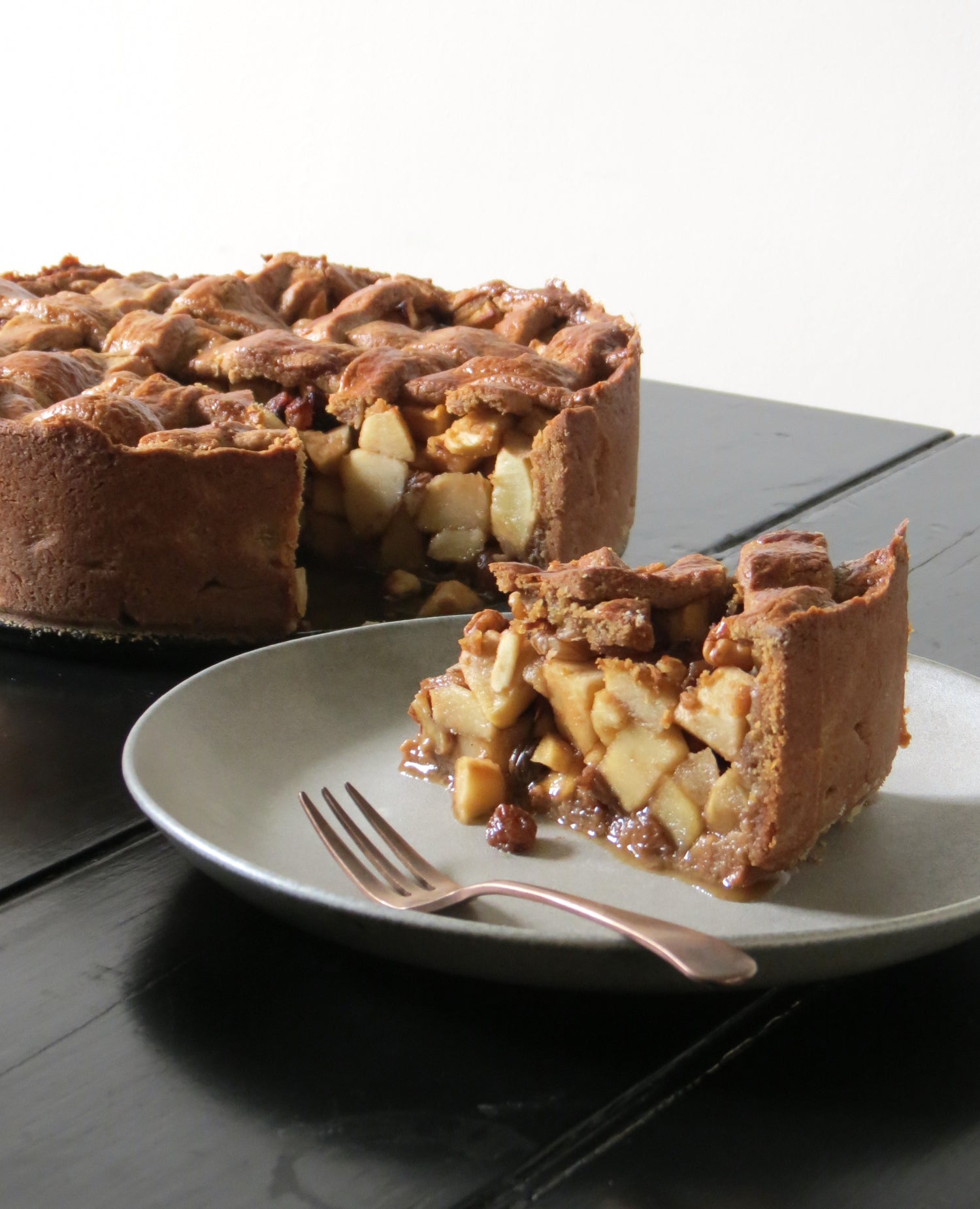 Recipe for Dutch Style Apple Pie. Slice of pie in side plate in front of the rest of the pie. 