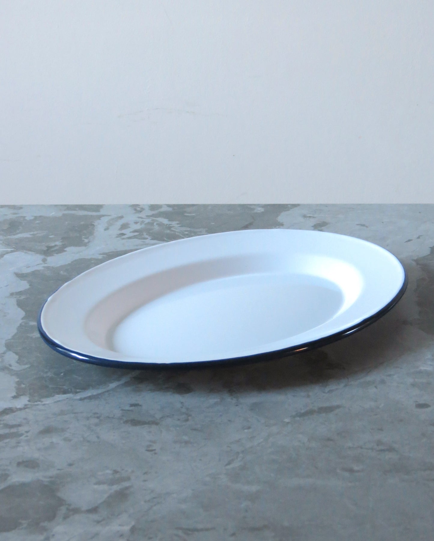 White plate with blue rim on a gray surface