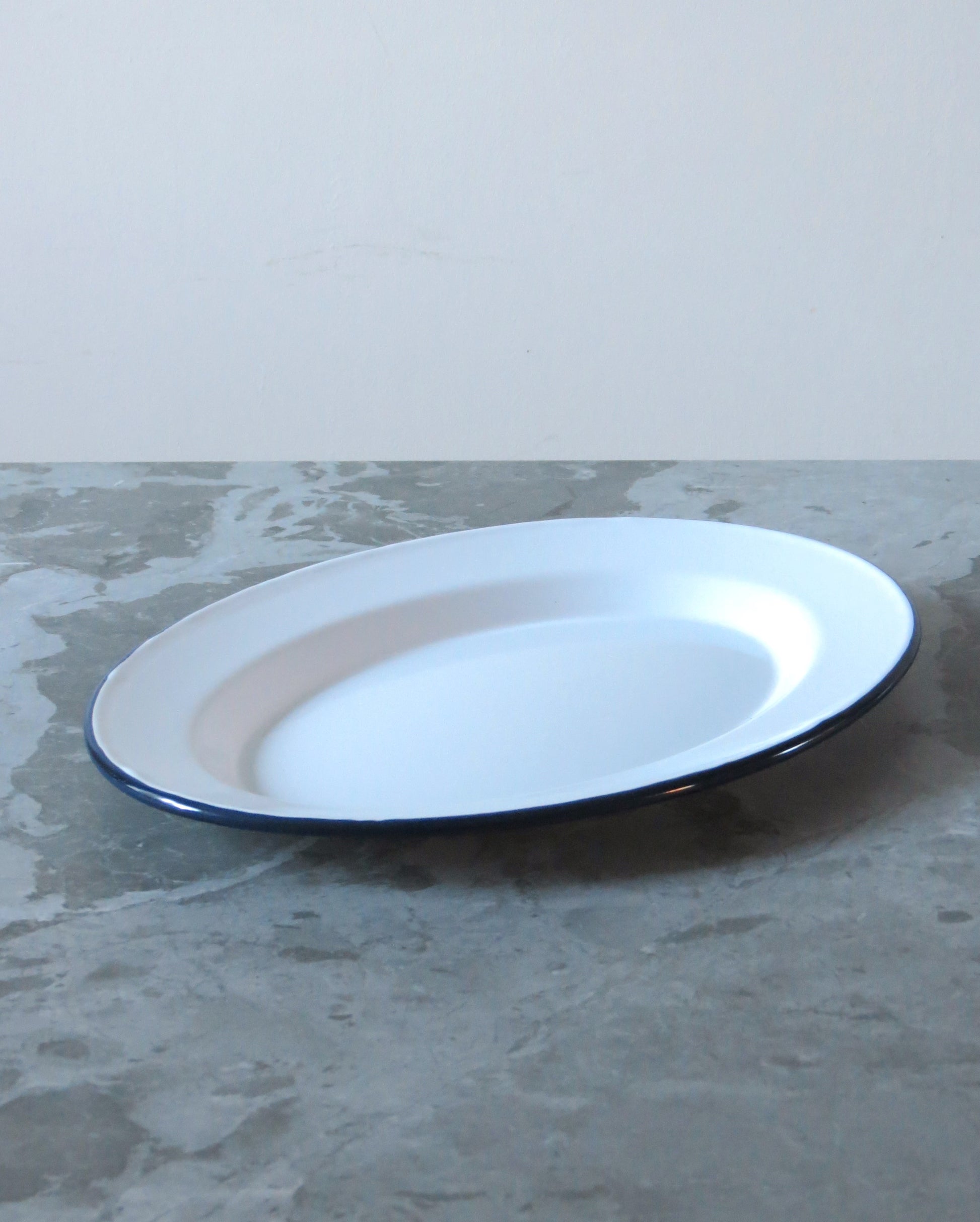 White plate with blue rim on a gray surface