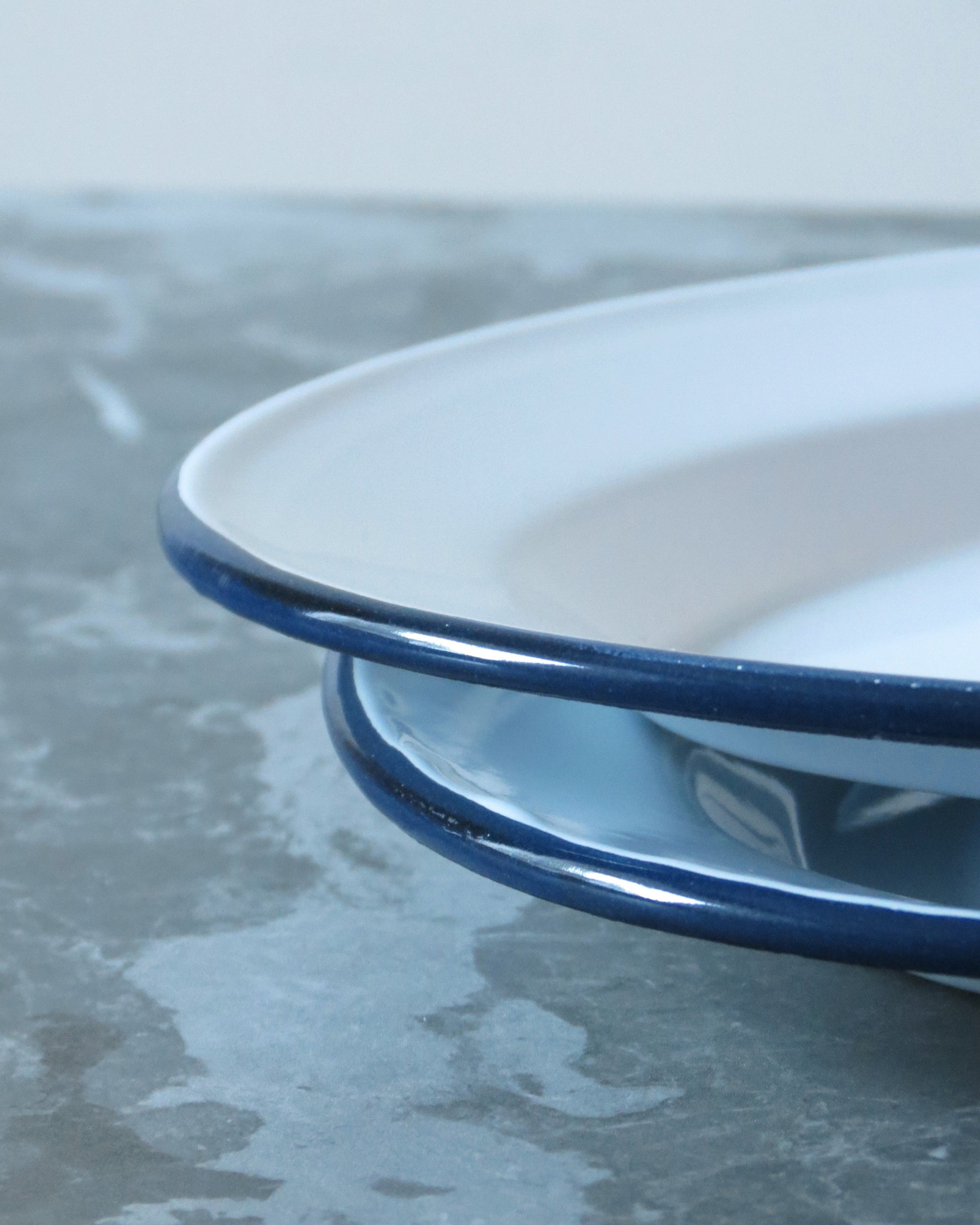 Close-up of a white dish with blue rim on a textured surface