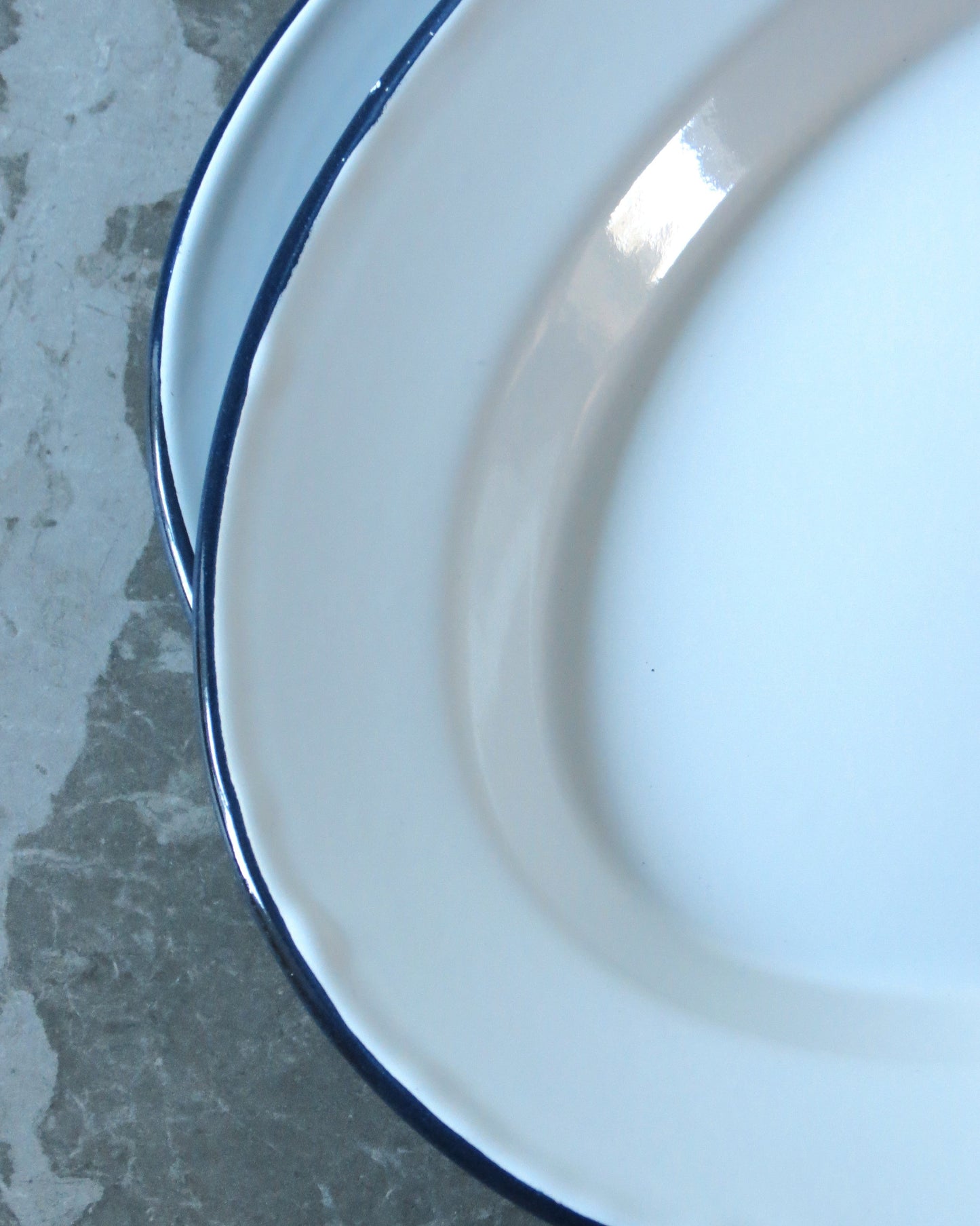 Close-up of a white plate with a blue rim on a gray surface