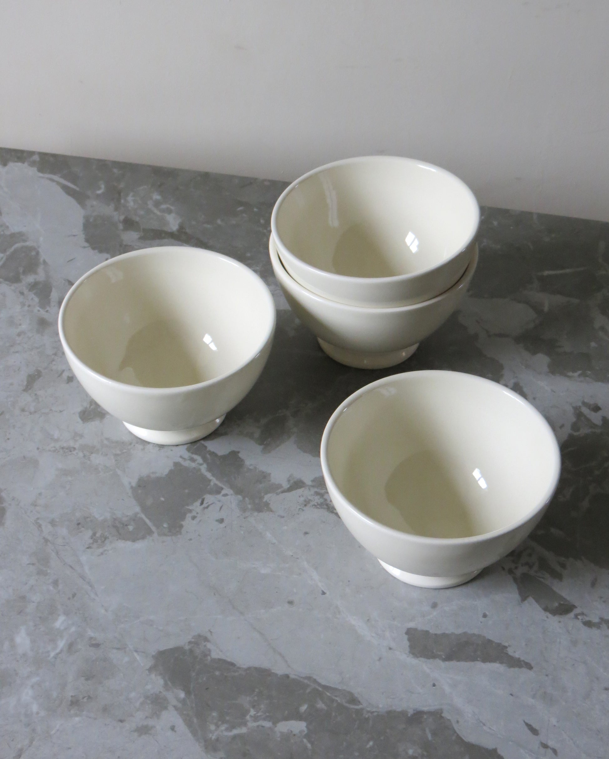 Three white ceramic bowls on a grey marble surface.