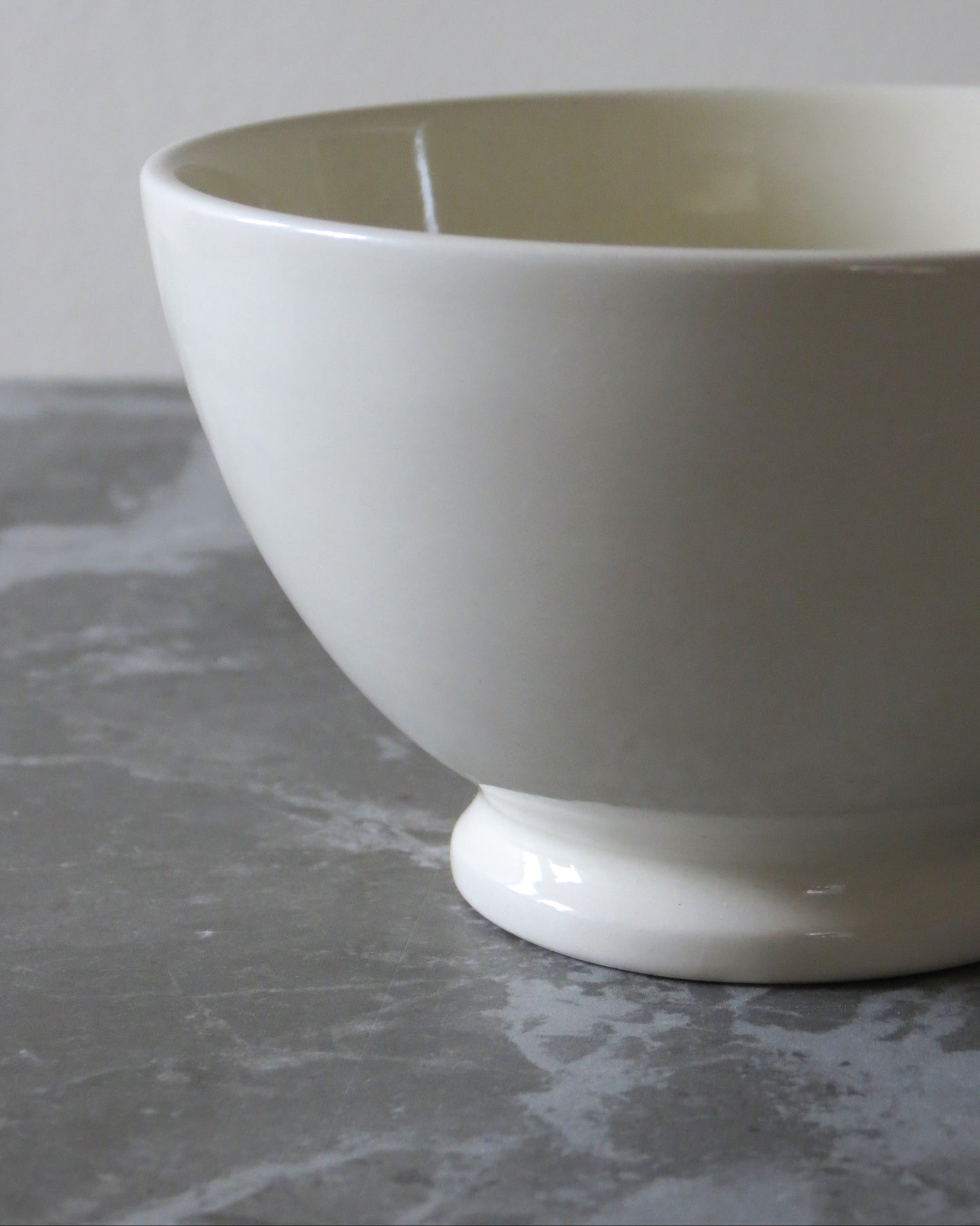 White ceramic bowl detail on a grey surface