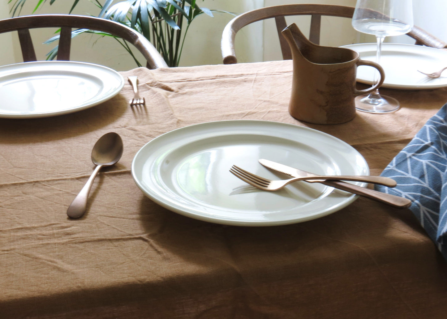 Dining table set with plates, cutlery, and a pitcher.