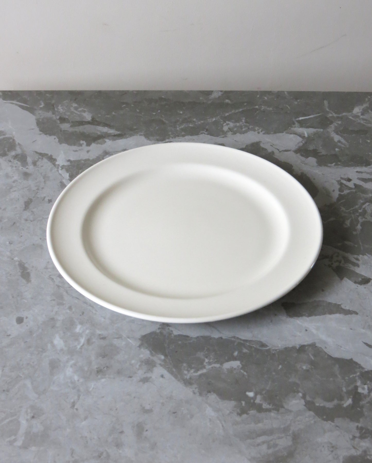 White plate on a grey concrete surface