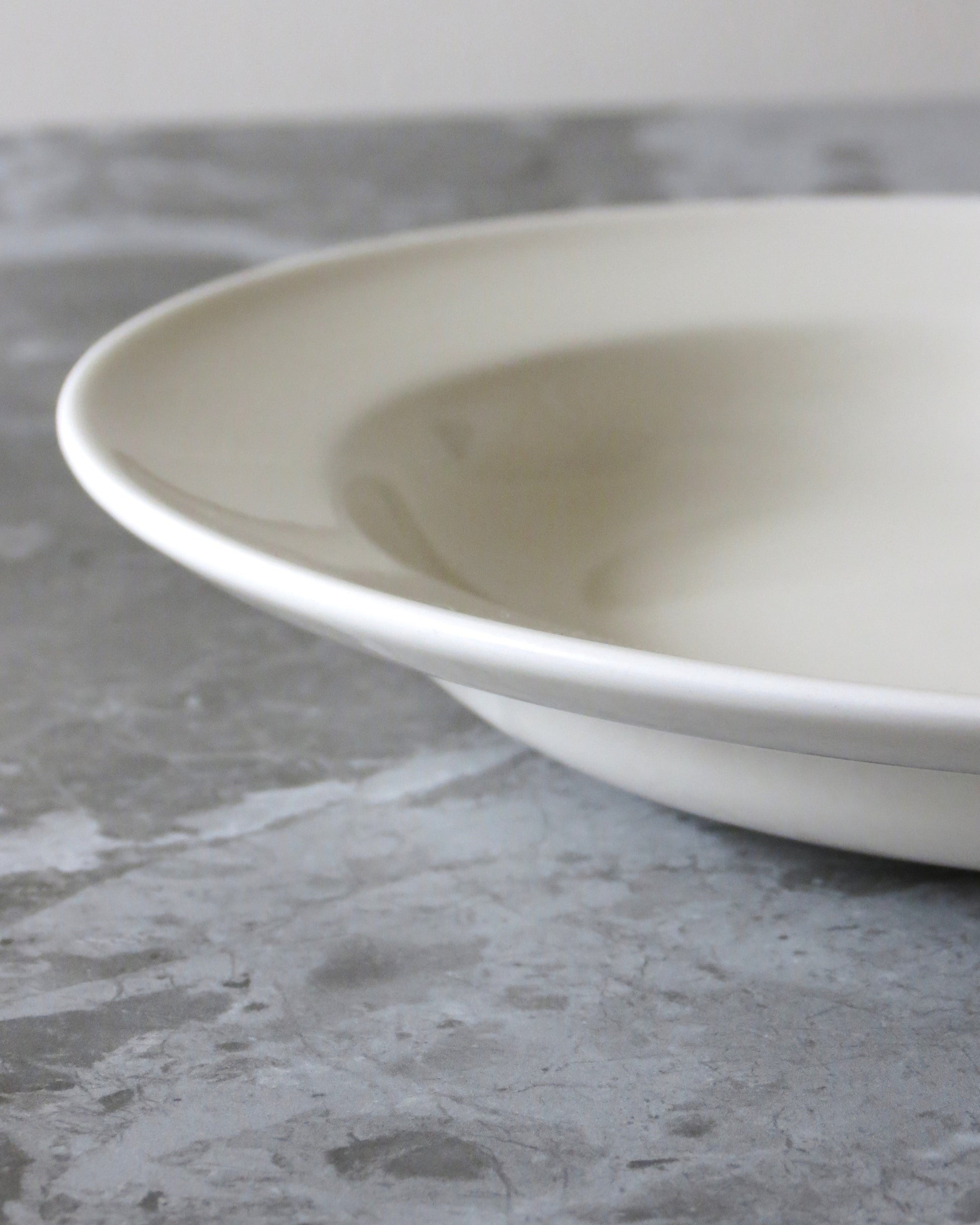 White ceramic bowl on a grey concrete surface
