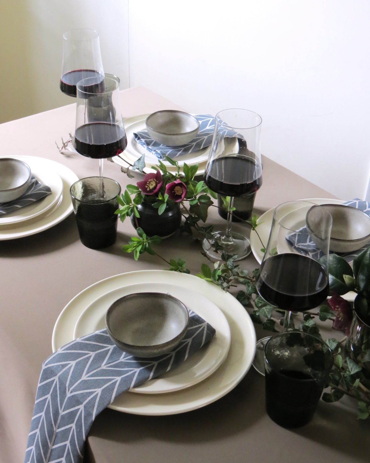 Elegant table setting with wine glasses and decorative napkins.