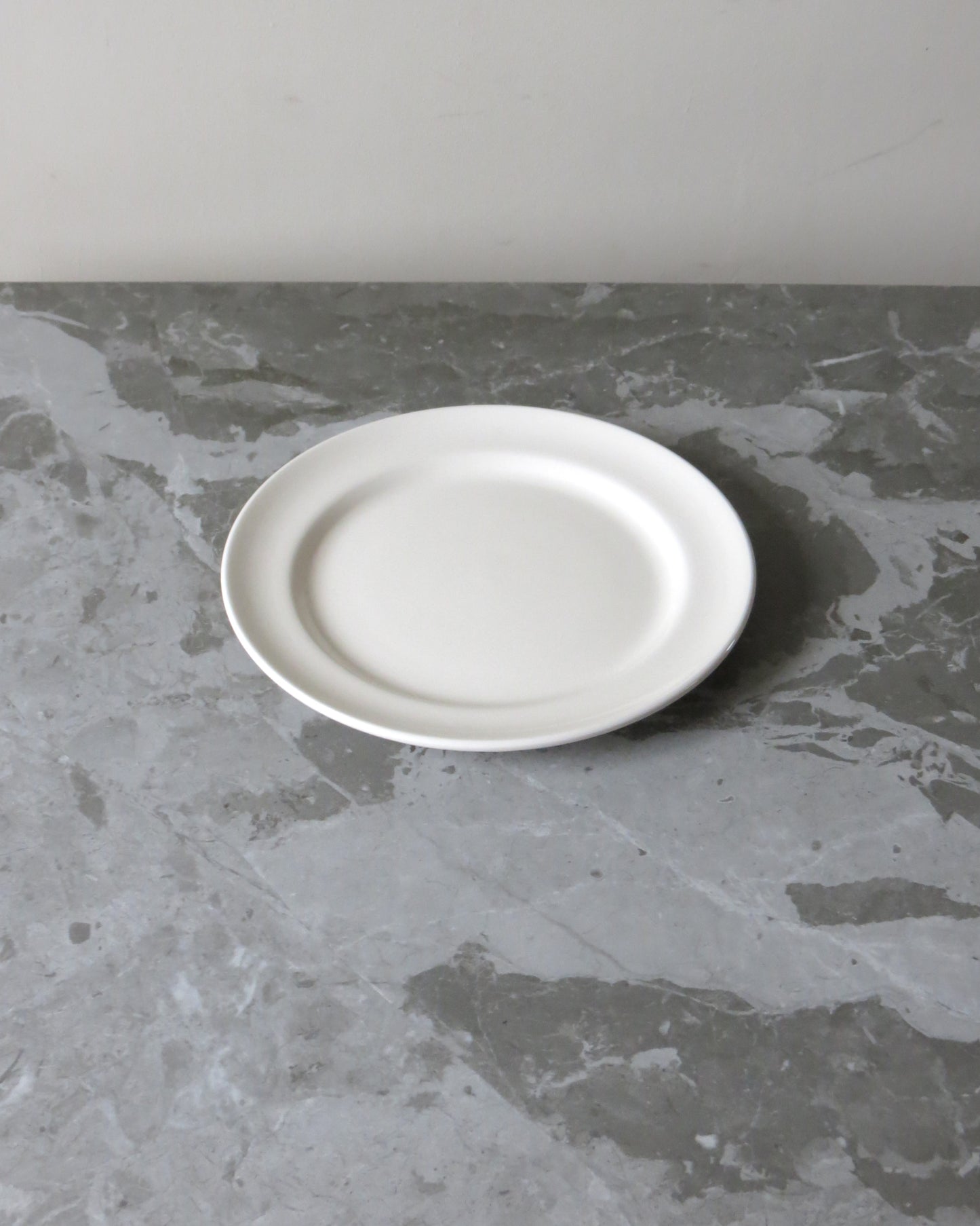 White plate on a grey marble surface