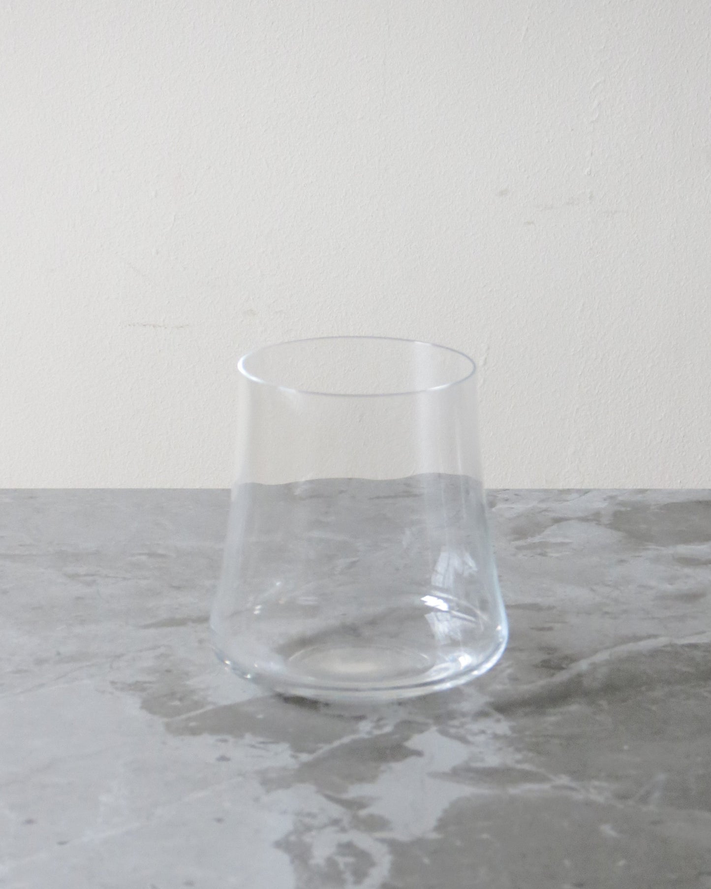 Clear glass on a grey marble surface with a white background