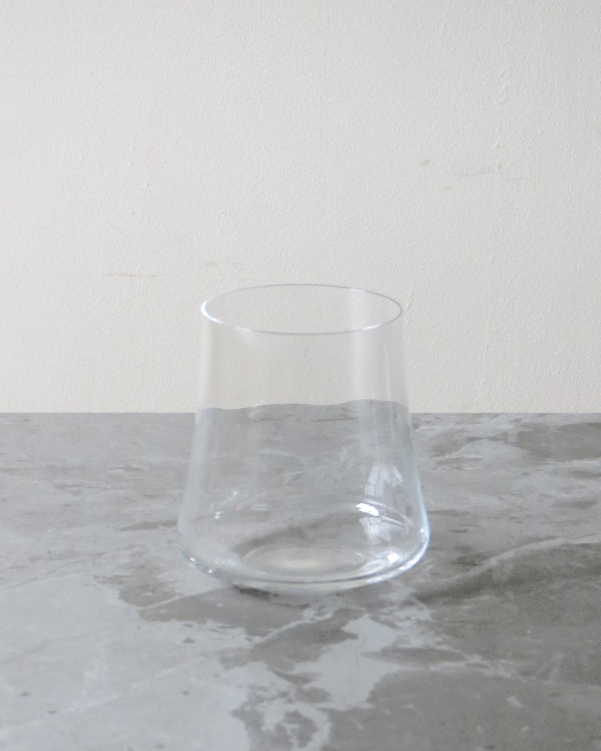 Clear glass on a grey marble surface with a white background