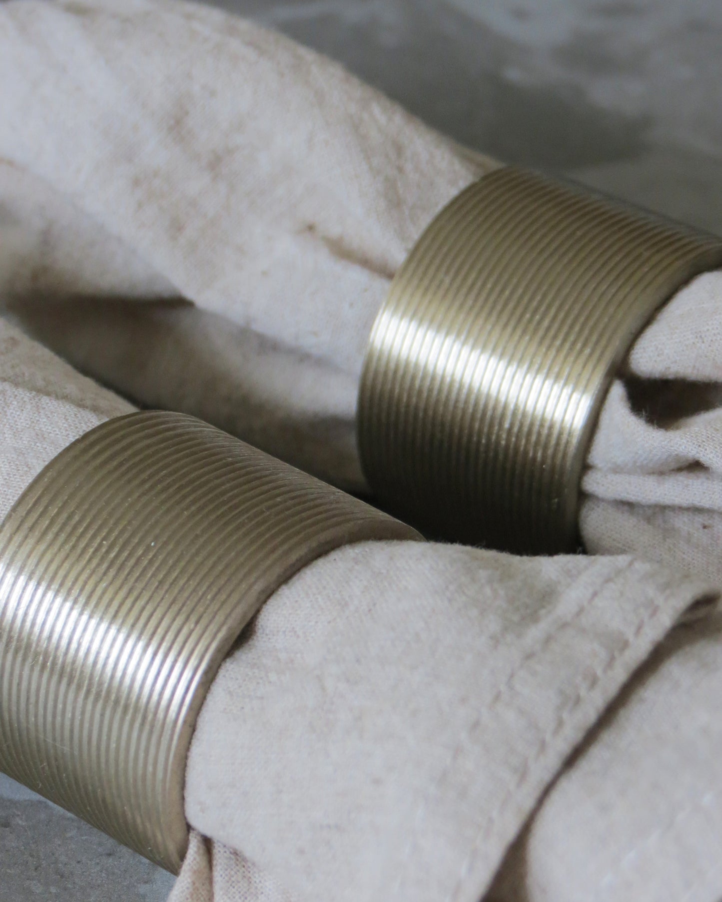 Close-up of two spools of beige thread on a textured surface