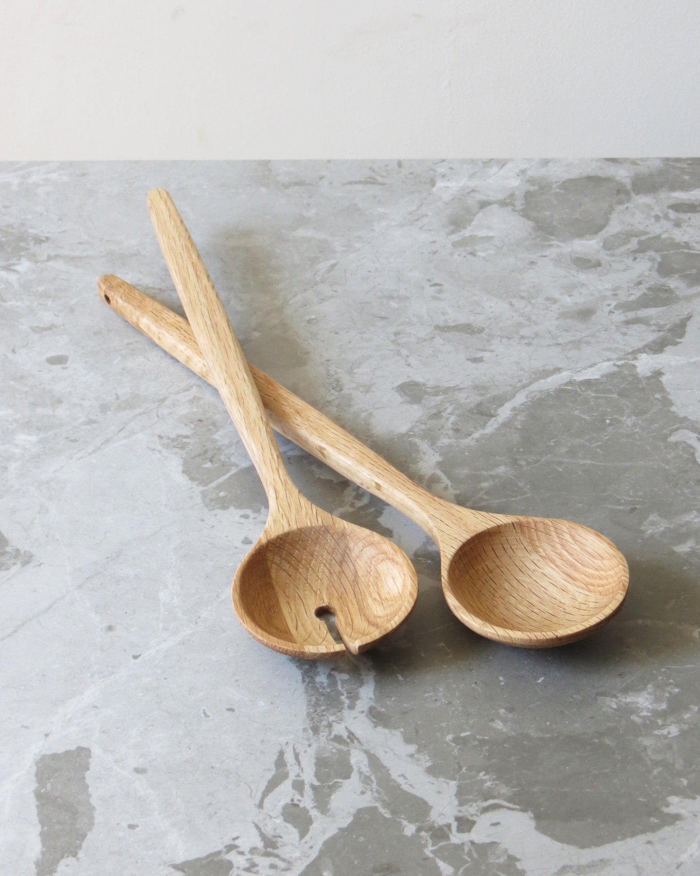 Two wooden spoons on a grey marble surface
