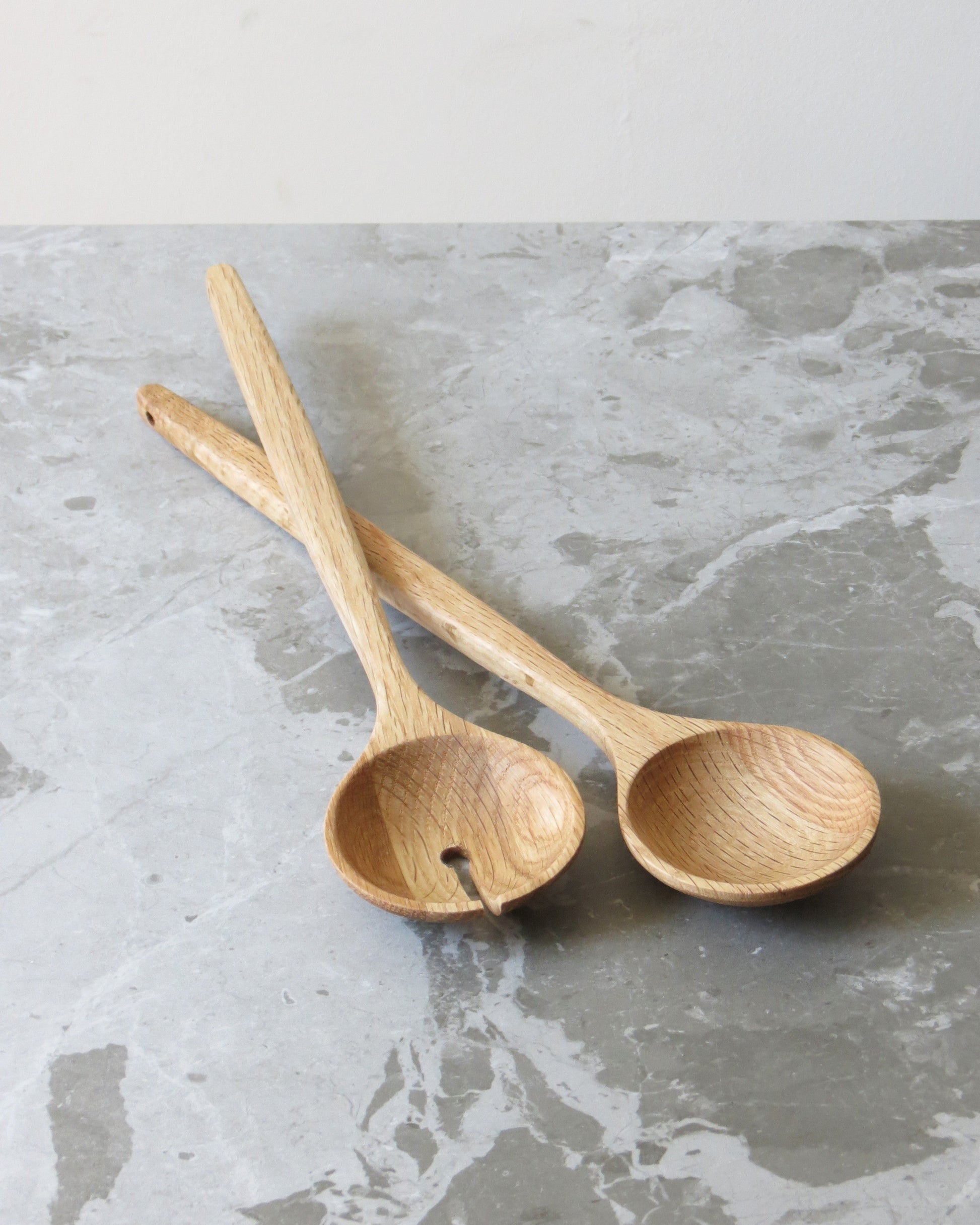 Two wooden spoons on a grey marble surface