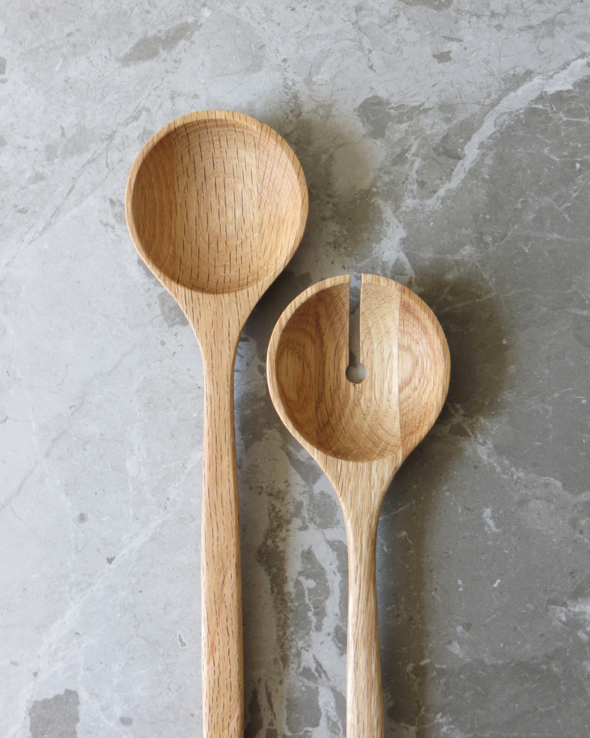 Two wooden spoons on a grey stone surface