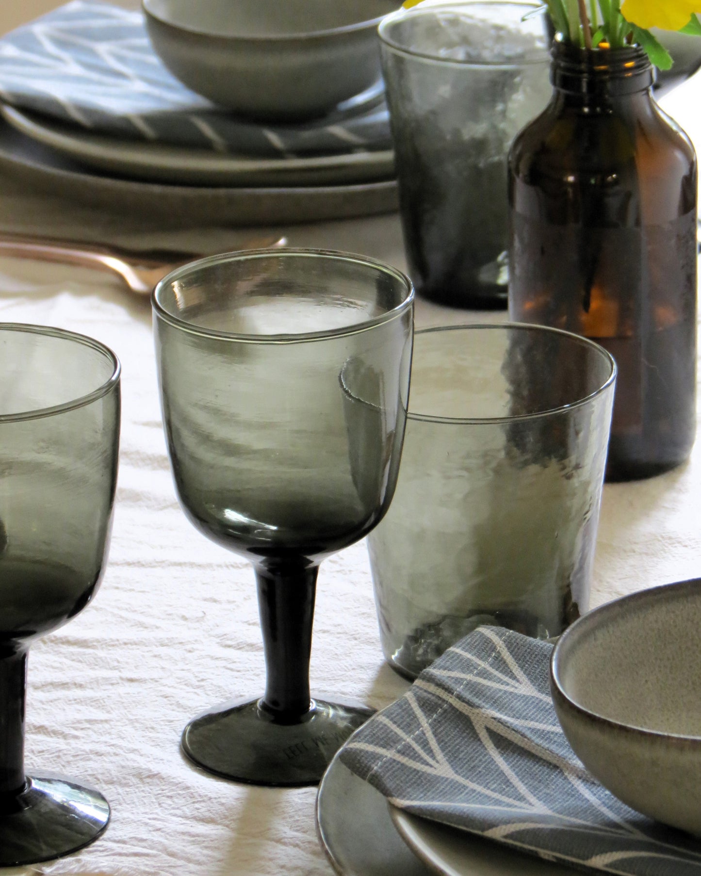 Dark glassware and bowls on a table setting.