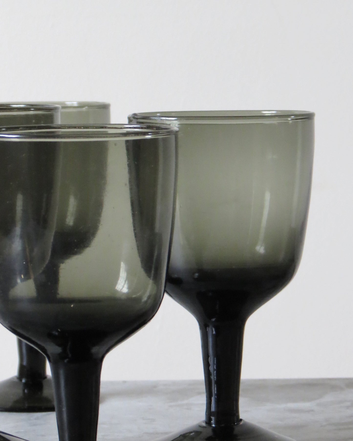 Set of smoked wine glasses on a marble surface.