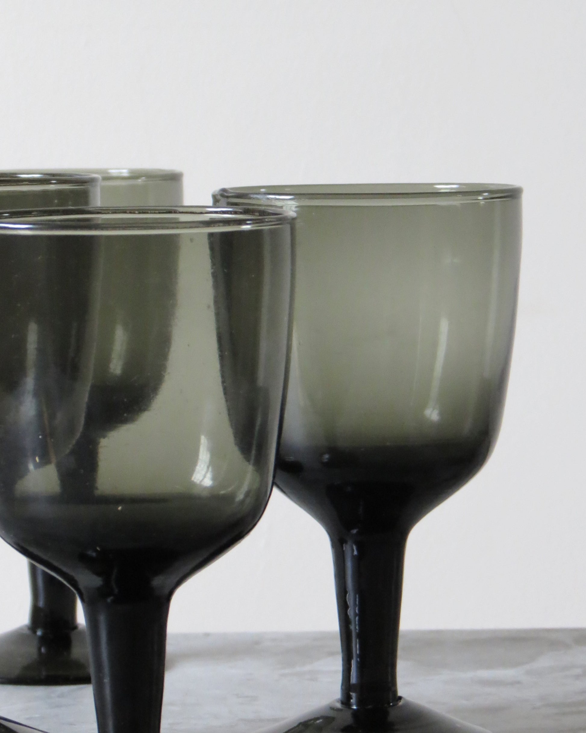 Set of smoked wine glasses on a marble surface.