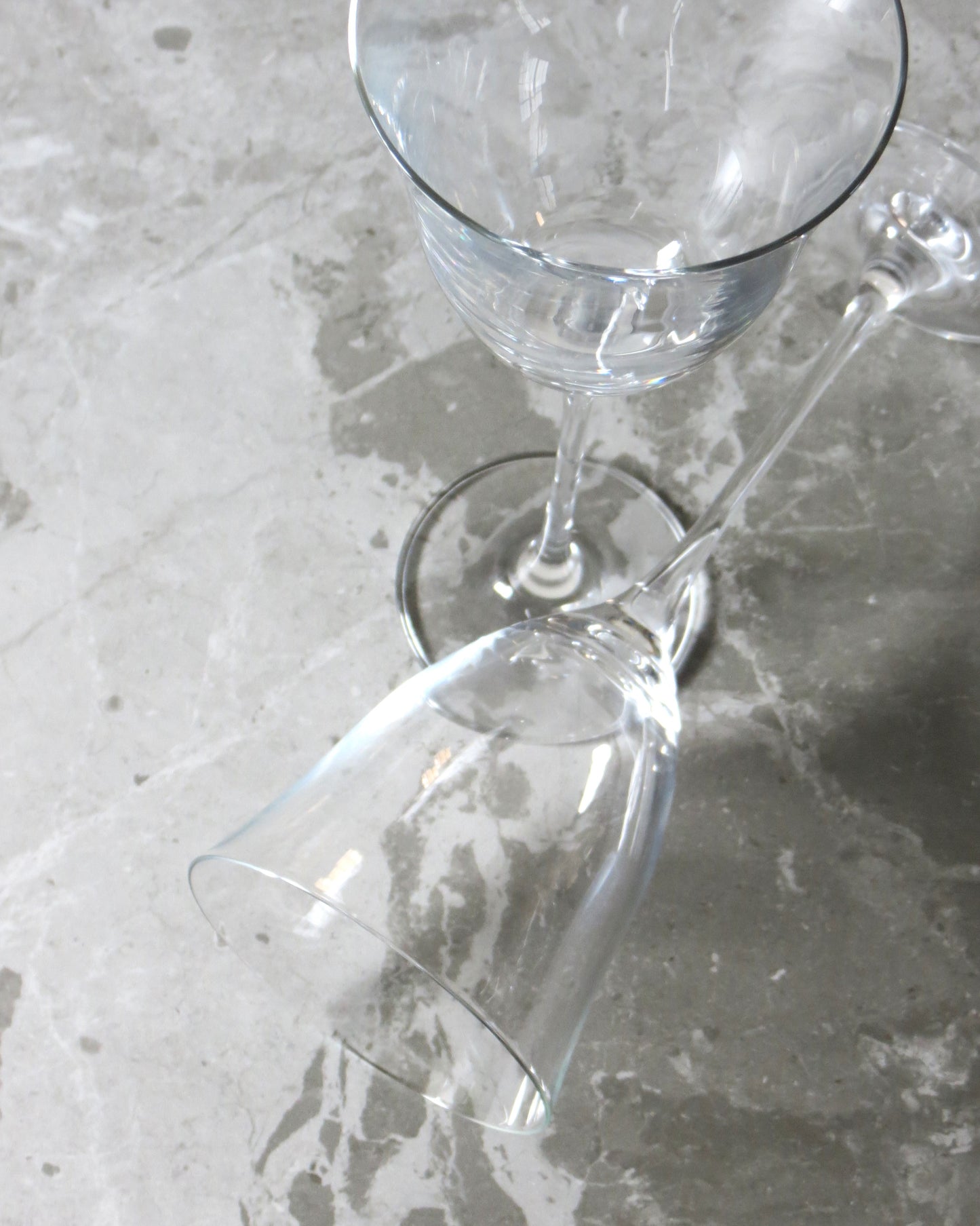 Clear glass wine glasses on a textured surface