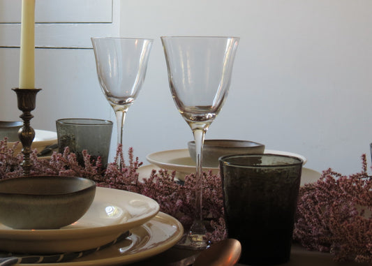 Elegant table setting with wine glasses and place mats.