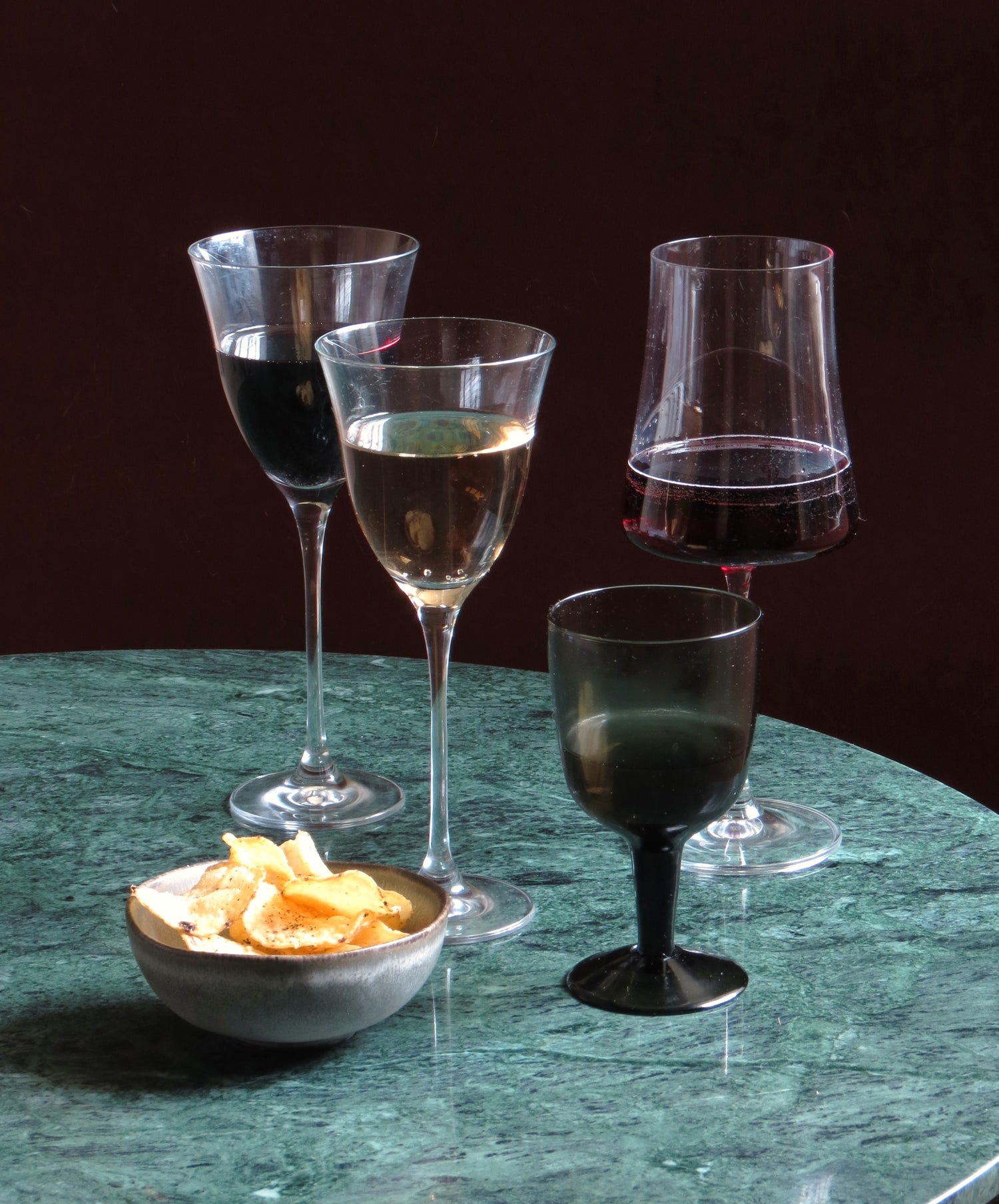Four different wineglasses on marble table. 